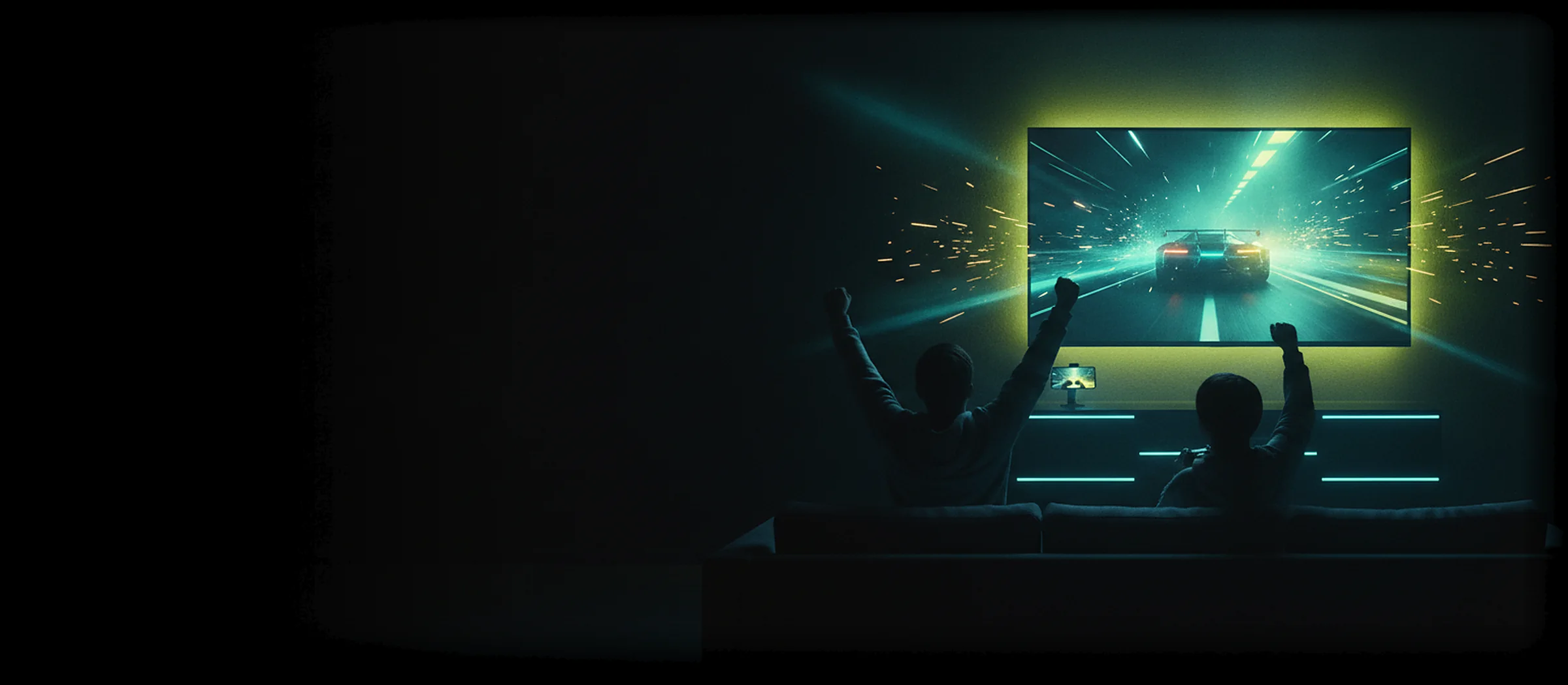 Two friends celebrating on a sofa while a PC game streams to a huge TV in a dark living room